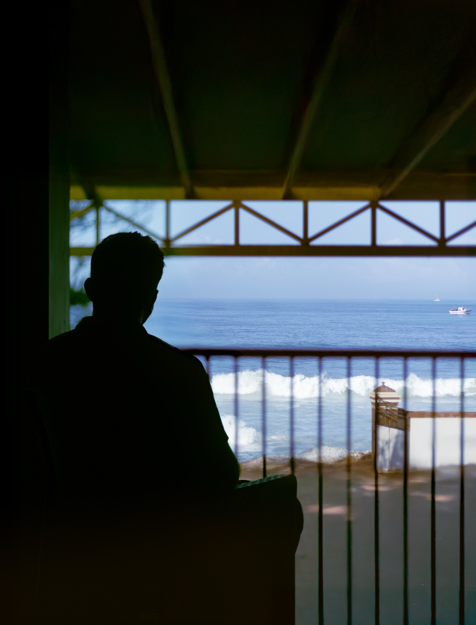 A guest on the first-floor balcony looking out at the waves
